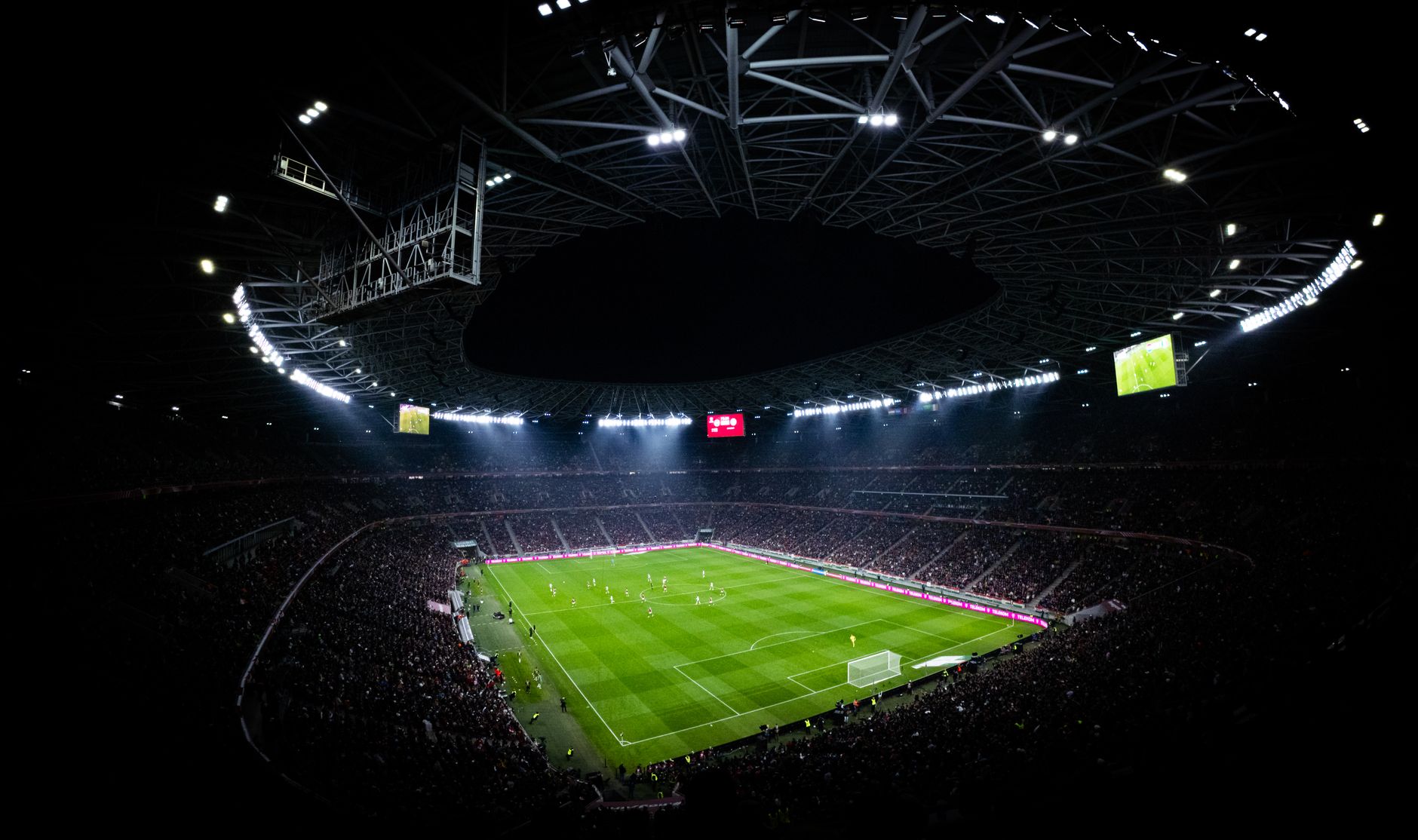 Football stadium under floodlights at night